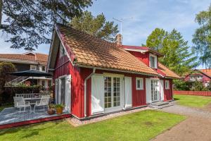 a red house with a patio in a yard at Vila Pervalka in Pervalka