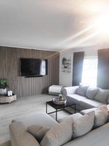 un soggiorno con un divano e una TV di House with large hot tub in Bø, room for 2 families! a Nordbø