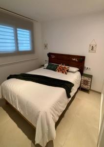 een slaapkamer met een bed met witte lakens en een raam bij TARIFA MOON The best place to be in Tarifa +30 foto's