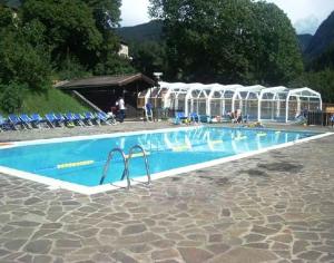 una piscina con sillas y sombrillas alrededor en Sporting Hotel Club, en Pelos