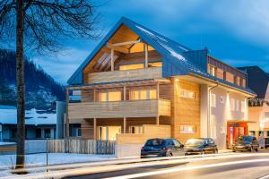 a house with two cars parked in front of it at Fleischerei - Apartments, Cafe & Weinbar in Hinterstoder