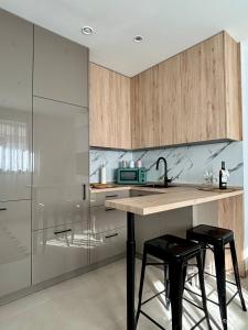 een keuken met een aanrecht met 2 krukken en een wastafel bij TARIFA MOON The best place to be in Tarifa