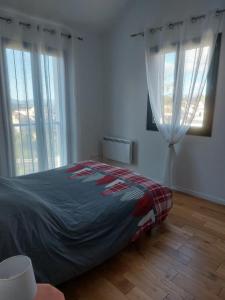 a bedroom with a bed and two windows at Maison de vacances à la montagne avec vue panoramique in Bolquere Pyrenees 2000