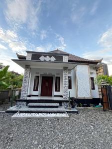 a small white house with a driveway at Alca House in Airsatang