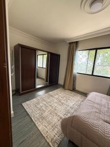 Un dormitorio con una cama y un espejo grande. en Warm 1BR in Dabouq, en Amán