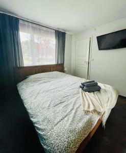 a bedroom with a large bed with a window at Cozy Family House with Sauna & Garden in Kärdla