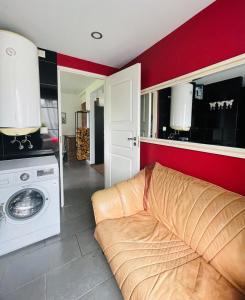 a living room with a couch and a washing machine at Cozy Family House with Sauna & Garden in Kärdla +4 photos