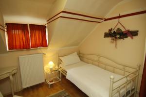 a small bedroom with a white bed and a window at Die Dependance in Neckargemünd