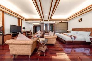 a large room with a bed and chairs and a television at Kunming Tailong Hongrui Hotel in Kunming