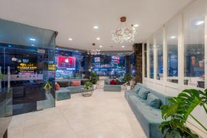 a lobby with couches and plants in a building at Tarasa Hotel by Elite24 in Danang