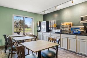 two tables and chairs in a restaurant with green walls at Days Inn by Wyndham Black River Falls - Access to ATV Trail in Black River Falls