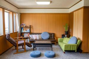 a living room with a couch and chairs and a table at Other Side House in Nakafurano