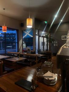una sala da pranzo con tavoli e sedie e una finestra di On Top Backpackers a Dunedin