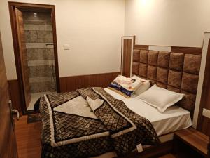 a small bedroom with a bed and a shower at Avadh Palace in Shimla