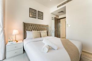 Ένα ή περισσότερα κρεβάτια σε δωμάτιο στο Community and Pool View 3BR Townhouse, Minutes from Desert Camp,DAMAC Hills 2 Amargo by Deluxe Holiday Homes +23 φωτογραφίες