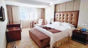 a large bedroom with a large bed and a chair at Dalian Southern Airline Pearl Hotel in Dalian
