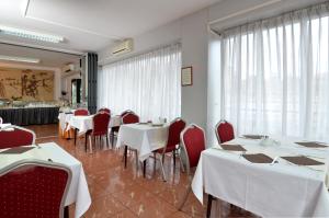 een eetkamer met witte tafels en rode stoelen bij Hotel Neboder in Rijeka +33 foto's