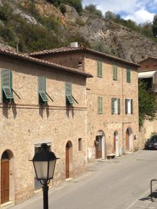 a large brick building with green shutters and a street light at Borgo Rosia Holiday House in Rosia