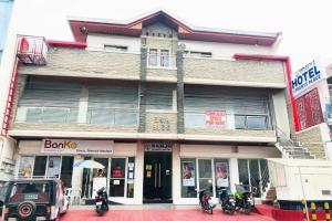 a building with motorcycles parked in front of it at SANJH Island Hotel powered by Cocotel in Roxas