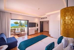 A bed or beds in a room at Ramada Loutraki Poseidon Resort