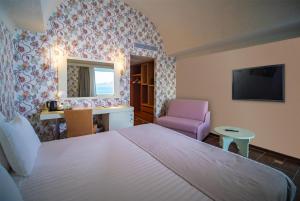 A bed or beds in a room at Ramada Loutraki Poseidon Resort