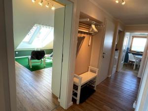 a hallway with a room with a chair and a window at FerienNest Kelheim in Kelheim +17 photos