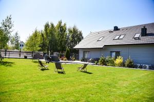 a yard with chairs and a table and a house at Vrij Ferienhaus in Zastań