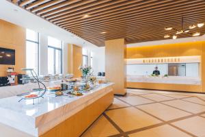 a lobby with a counter with food on it at Atour Hotel (Suzhou Xiangcheng) in Suzhou