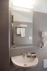a bathroom with a white sink and a mirror at Hotel Gabbiano in Rimini +37 photos