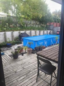 a patio with a blue table and a chair at House On The Hill in Hamilton
