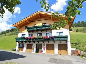 un edificio con dei fiori sul lato di Modern Holiday Home in Maria Alm near Ski Area a Maria Alm am Steinernen Meer