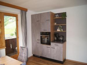 a kitchen with a stove and a microwave at Holiday apartment near ski area in Aschau