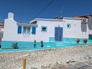 a white and blue house with a blue door at Seesterne in Estrela