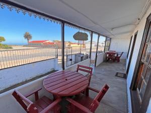 a table and chairs on a balcony with a view of the ocean at Grazia Cottages in Port Nolloth