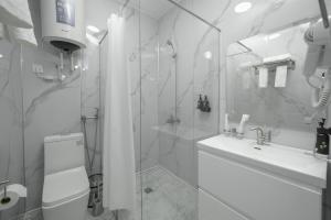 a bathroom with a shower and a toilet and a sink at Sultan in Bishkek +34 photos