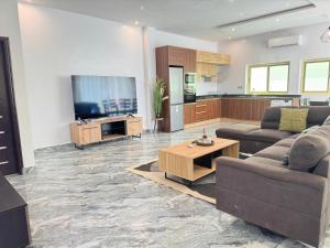 a living room with two couches and a television at RESIDENCE MH SERVICES Cotonou in Cotonou