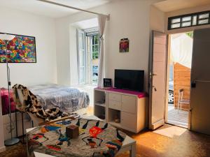 a living room with a bed and a tv at Friendly Africa Room Como Center in Como