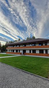 a building with a green lawn in front of it at Complexul Rustic in Avrig