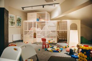 a room filled with toys and a child laying on the floor at Elements Hotel&Spa in Świeradów-Zdrój