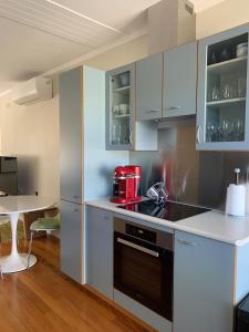 a kitchen with white cabinets and a red appliance at Stylish 2BR apt, great location in Campbell +18 photos
