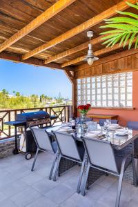 a patio with a table and chairs and a grill at Arguineguín Villa Hot Tub, BBQ & Views in Patalavaca
