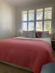 a bedroom with a large bed with a red blanket at Stylish 2BR apt, great location in Campbell