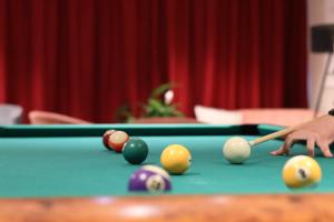 a person playing billiard with a cue on a pool table at Elements Hotel&Spa in Świeradów-Zdrój
