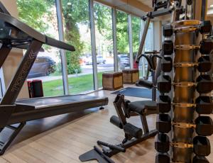 a gym with a bench and a tread machine at Lion's Garden Hotel in Budapest