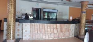 a woman sitting at a bar in a restaurant at Super Paradise Hotel in Kampala