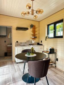 a kitchen with a table and chairs in a room at Willow Tiny House - ElysianFields in Sadu