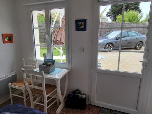 a room with a table and two chairs and a window at Logis du Pey Roux Accueil Marcheurs Vélos in Saint-Jean-de-Monts