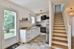 a kitchen with a staircase leading up to a window at Charmante maison proche mer, quartier paisible in Olonne-sur-Mer +35 photos