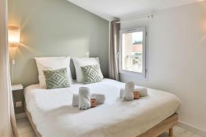 a bedroom with a large white bed with a window at Charmante maison proche mer, quartier paisible in Olonne-sur-Mer