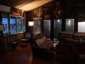 a living room with a couch and some windows at Muangkham in Chiang Rai